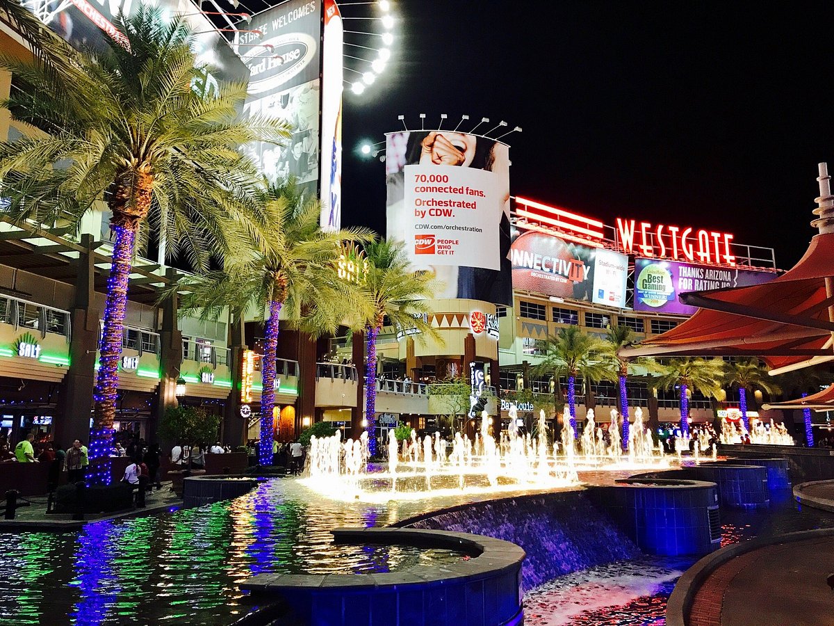 Westgate Entertainment District at night with palm trees, fountains and bright signage
