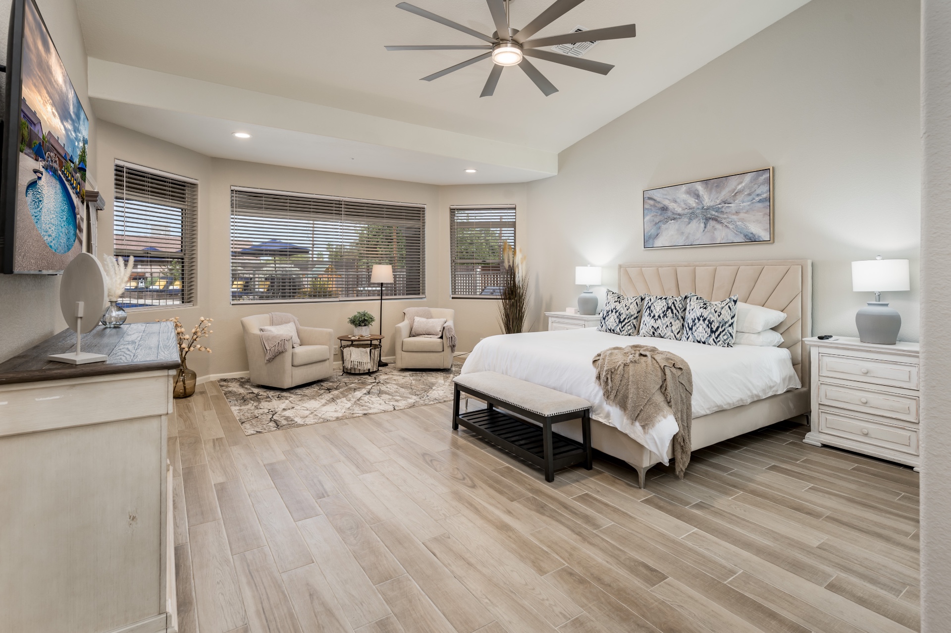 Primary bedroom with king bed, sitting area and vaulted ceiling