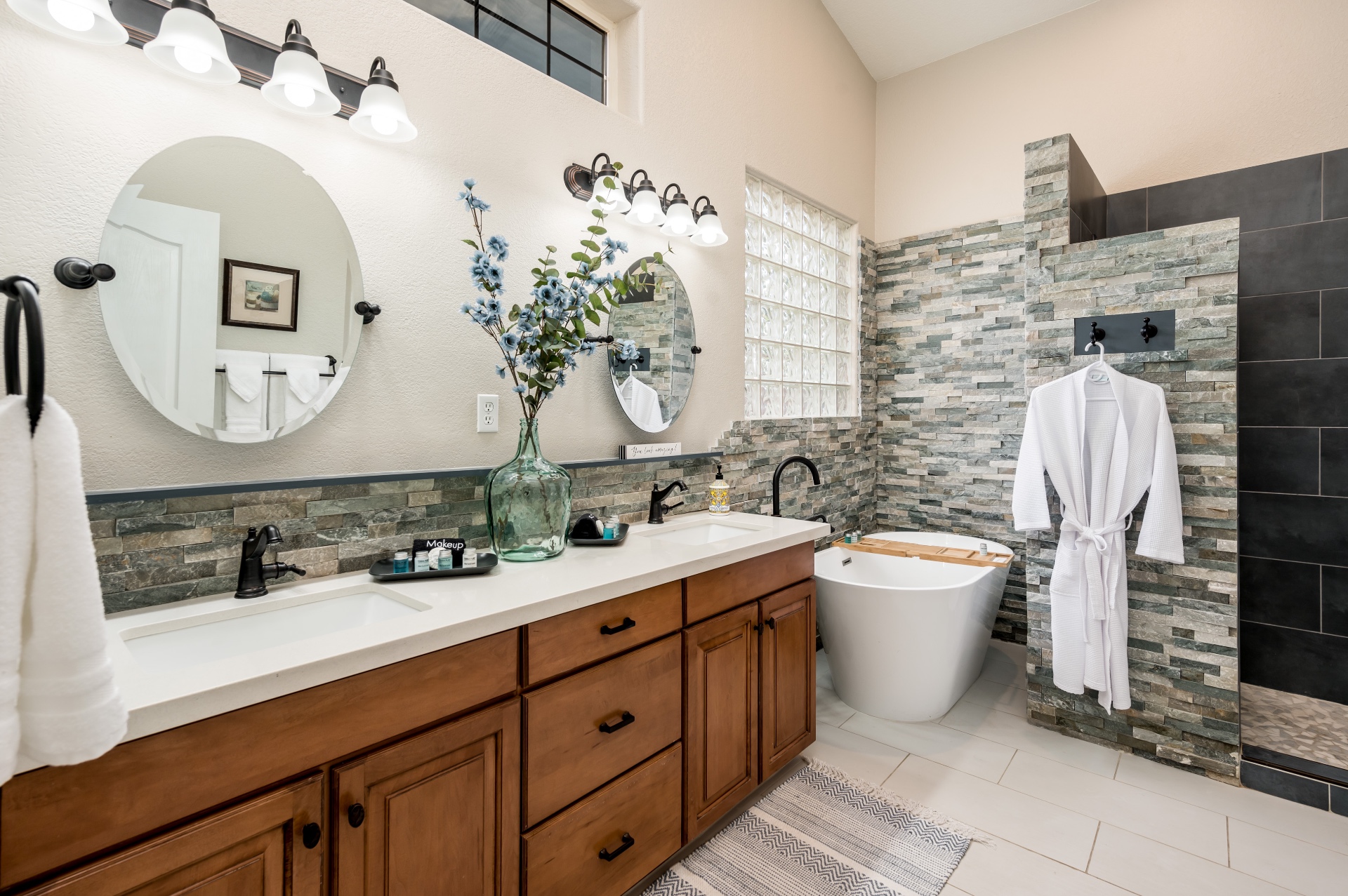 Primary bathroom with double vanity, soaking tub and walk-in stone shower