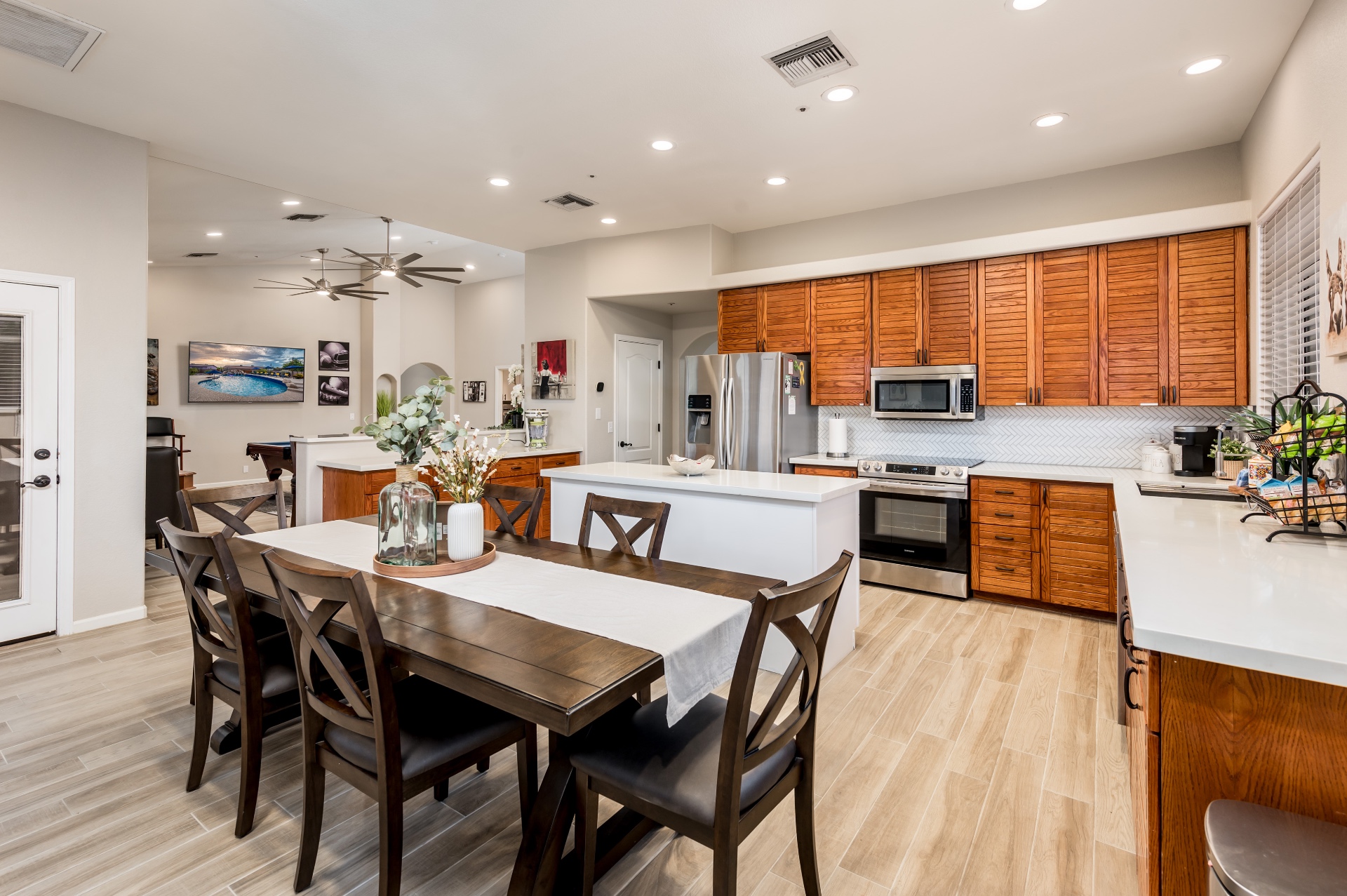 Kitchen with white quartz island, stainless appliances and dining table